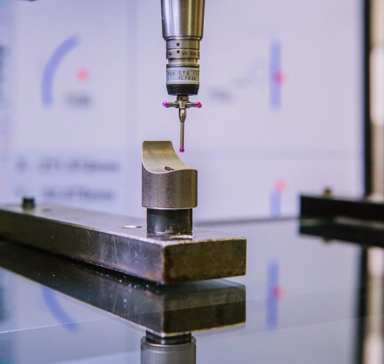 Coordinate measuring machine probing a machined component during quality inspection